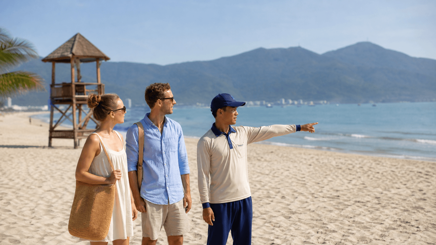 International travelers discussing sea conditions with a beach attendant on Da Nang coast